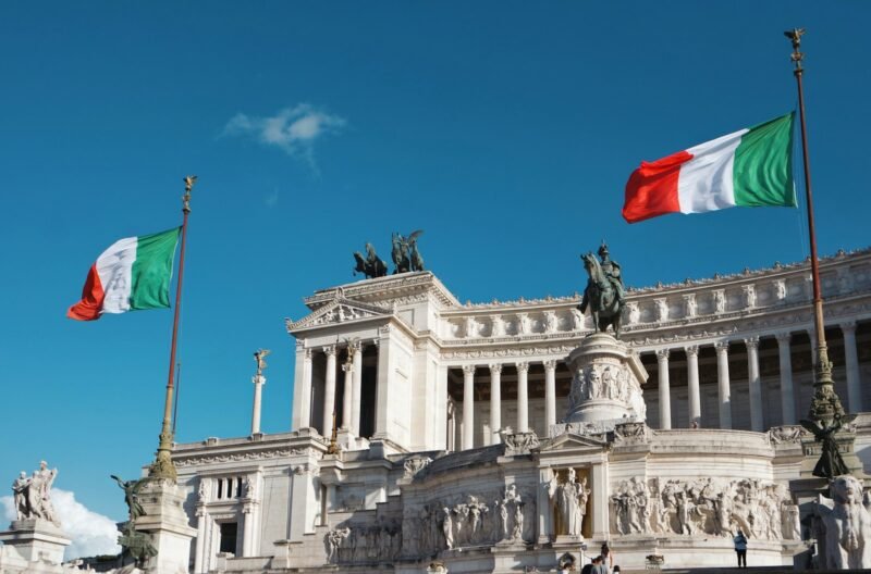 Noticias sobre Ciudadanía Italiana: Cambios y Desafíos para los Descendientes 3 white concrete building with red flag on top under blue sky during daytime